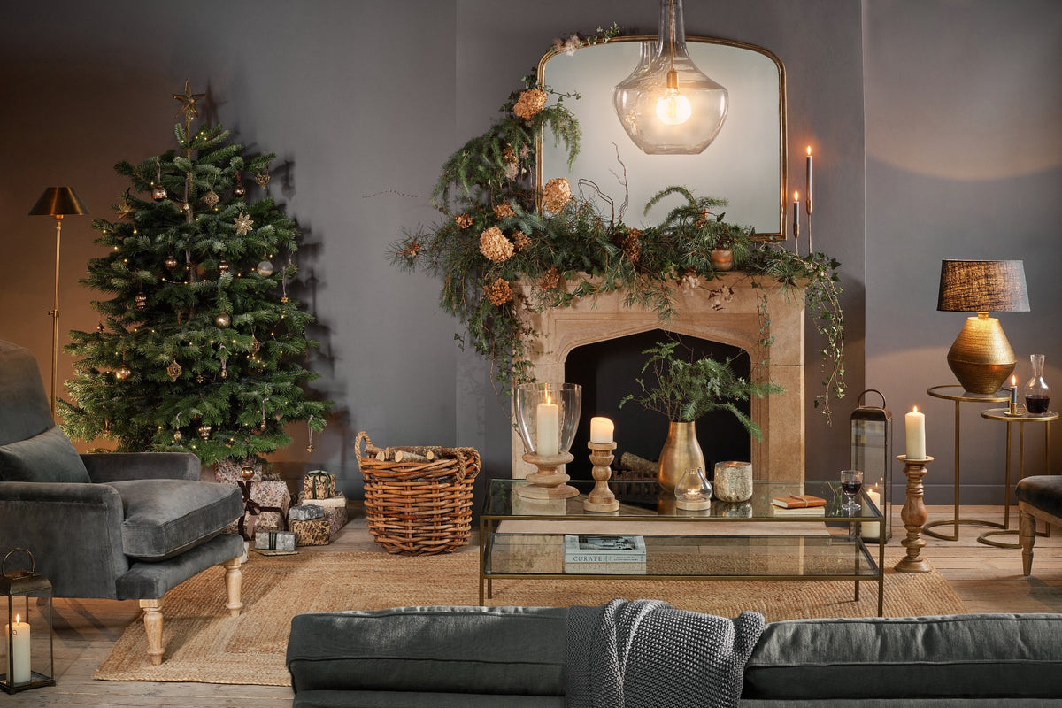 A softly lit Christmas living room with a decorated tree and festive greenery