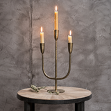 Nkuku Mbata three-arm candelabra in antique brass, framed prominently